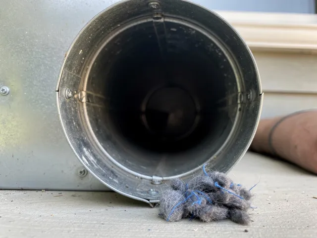 Lehigh Acres Dryer Vent Cleaning technician using specialized equipment to clear severe dryer vent blockage in Lehigh Acres
